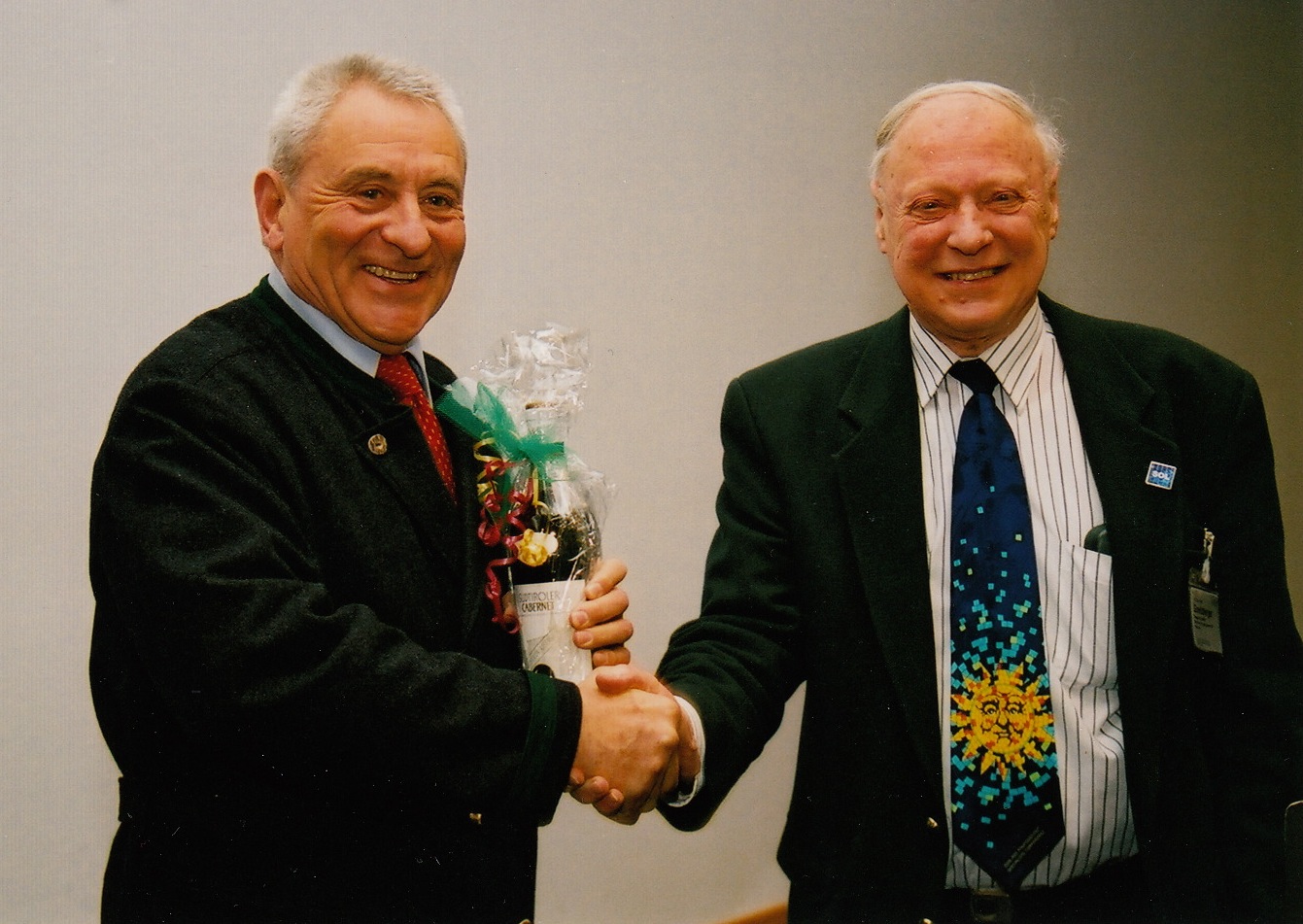 ©Detlef Koenemann. Ehrung der Staffelstein-Veteranen am 20. PV-Symposium 2005. Adolf Goetzberger überreicht Udo Möhrstedt eine Flasche Wein. 